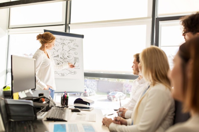 A woman makes a speech and uses visual aids to support her ideas