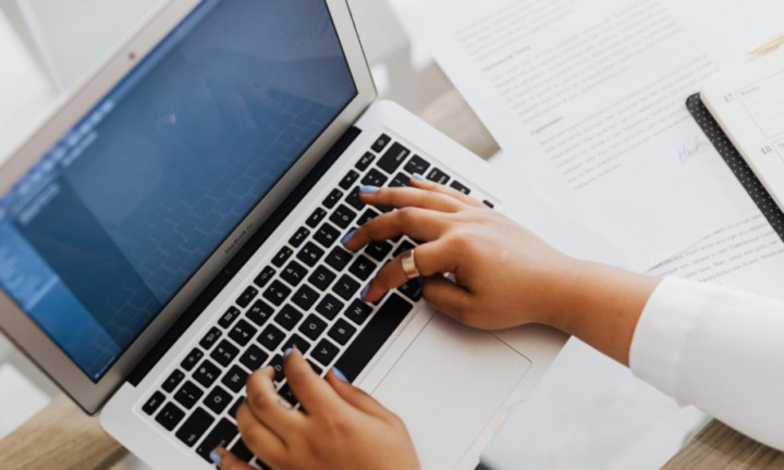 A person working on a text using her PC