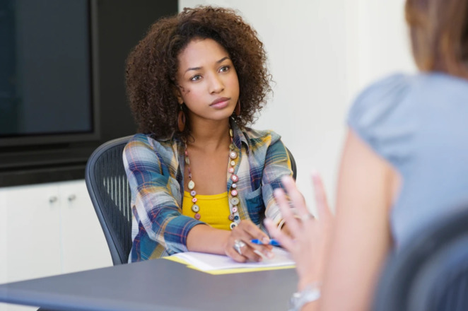 Two people talking and sitting at a table in college