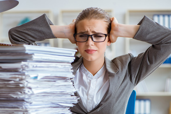 A person looking at a pile of papers